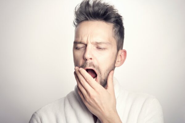 man yawning covering his mouth